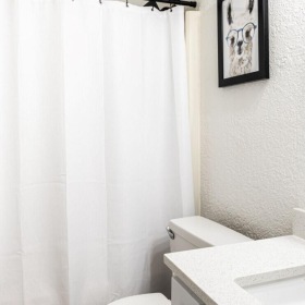 a bathroom with a white shower curtain and a sink