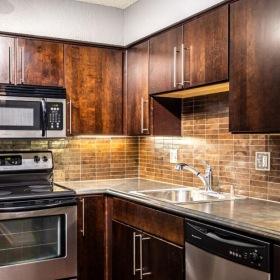 a kitchen with stainless steel appliances and dark wood cabinets
