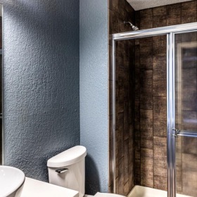 a bathroom with a glass shower a toilet and a sink